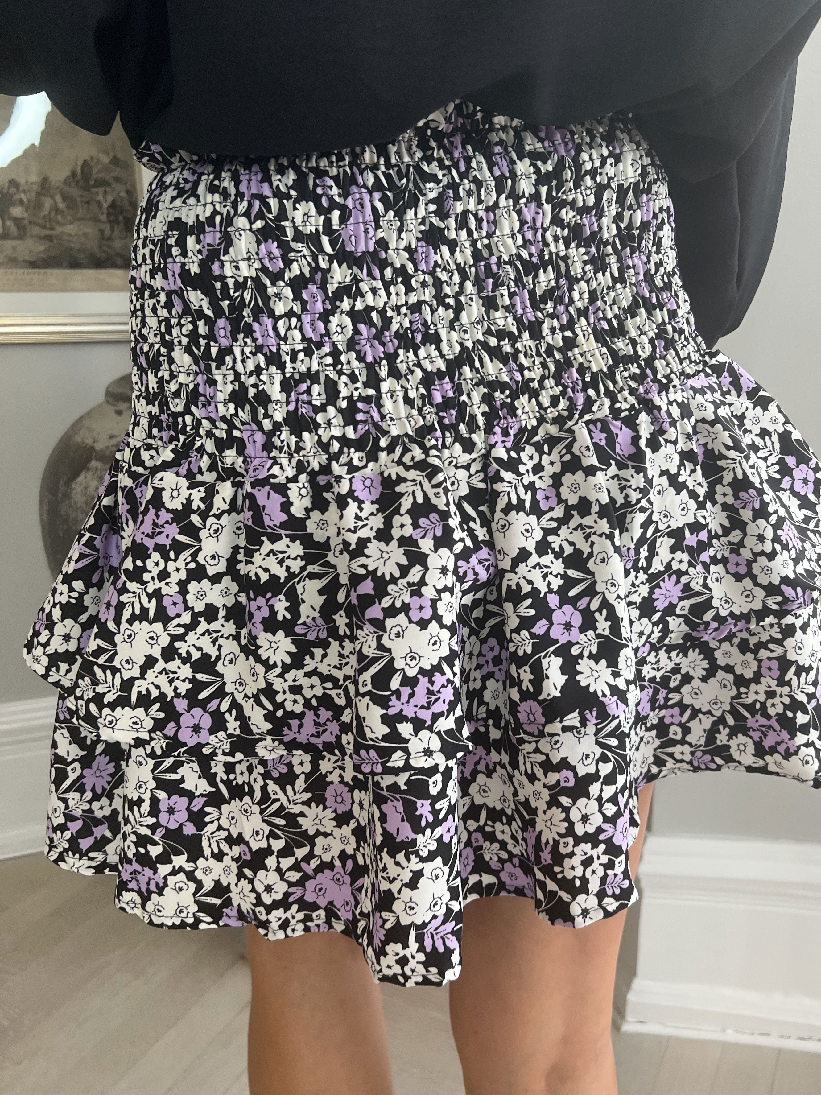 Augusta - Svart volangkjol med vitt och lila tryck